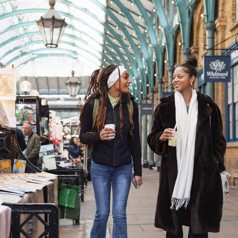 Students with coffee walking in the market.