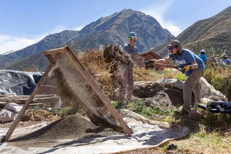Students work on a service project with shovels