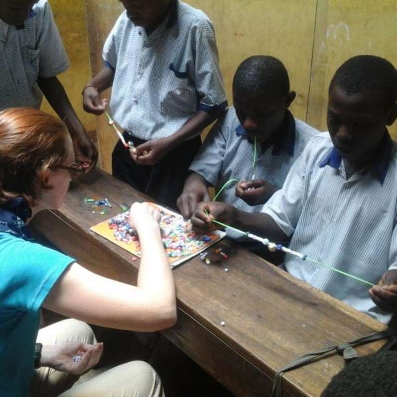 Volunteers making crafts with students in Uganda, Africa