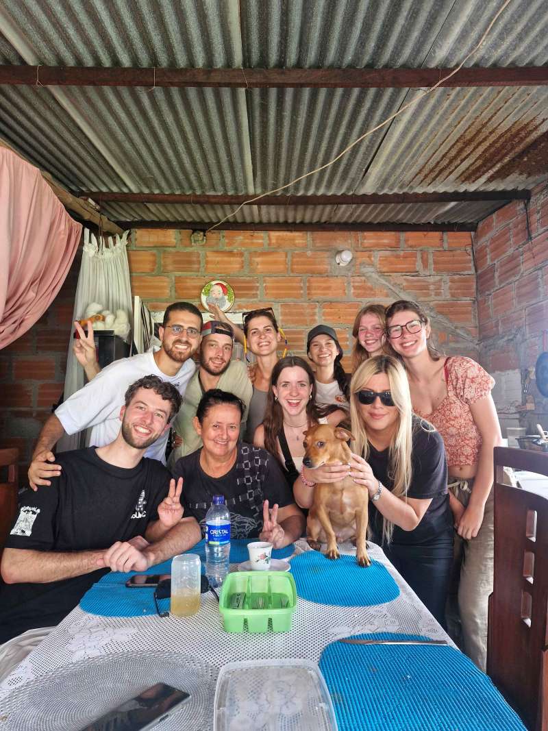 team of volunteers enjoying a traditional meal at a local family's home