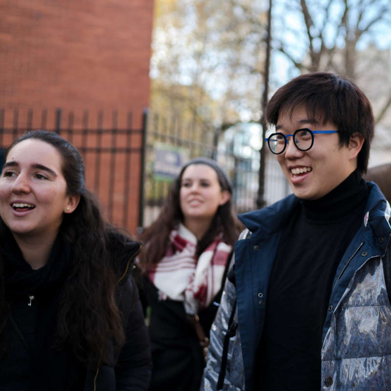 Three students outside, smiling.