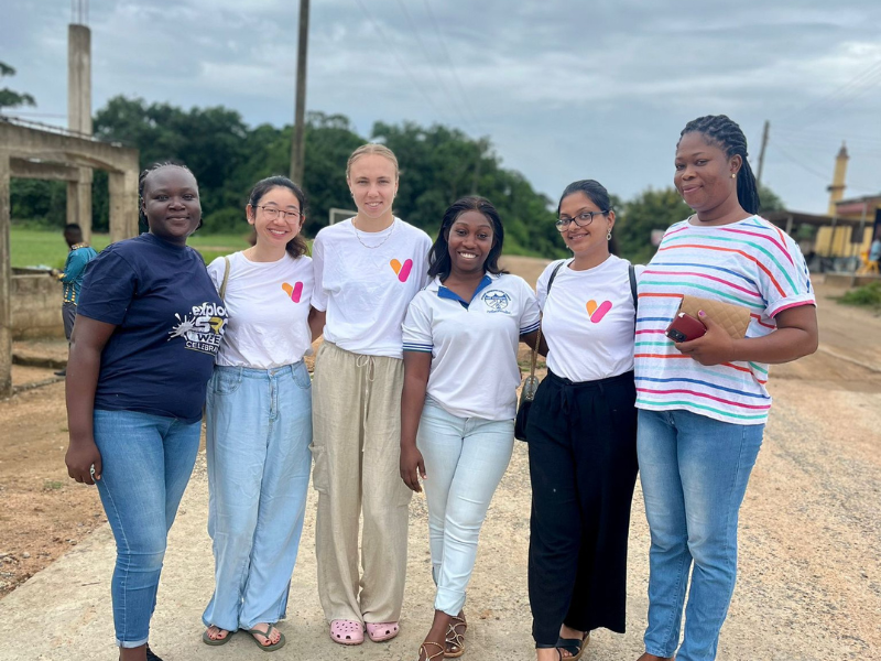 Three volunteers stand in Vocational Impact t-shirts with three members of the team in Ghana.