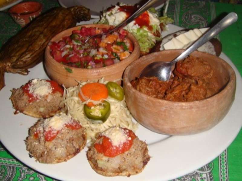 Traditional Mexican dishes including tacos, salsa, and fresh ingredients served on a table in Oaxaca, Mexico.