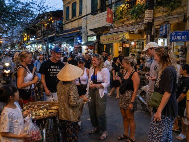 Travellers meeting a street vendor in Hanoi Old Quarter