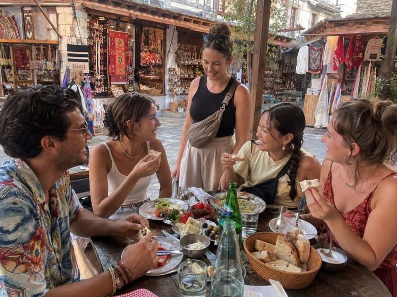 Travellers sharing lunch at a traditional Albanian market