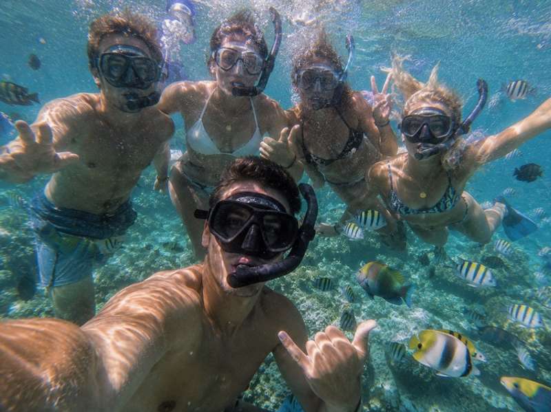 Travellers snorkelling with tropical fish in Thailand