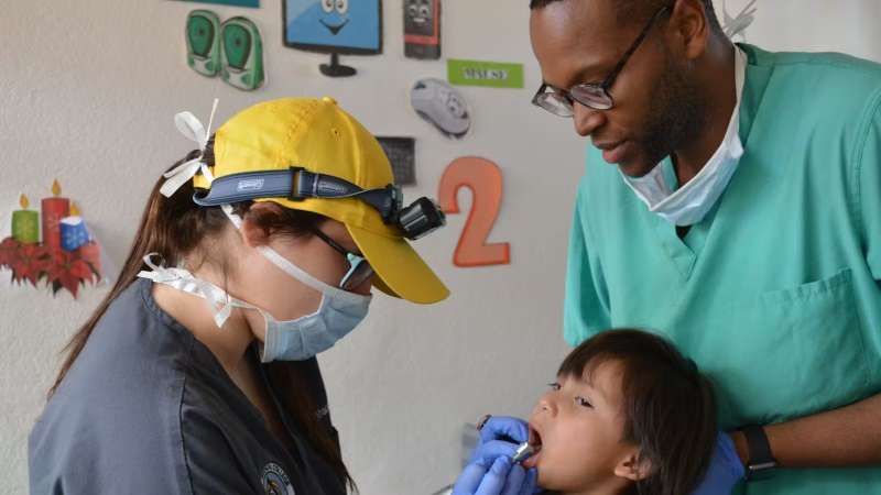 Two Dental Volunteering Checking a Childs Mouth in Costa Rica