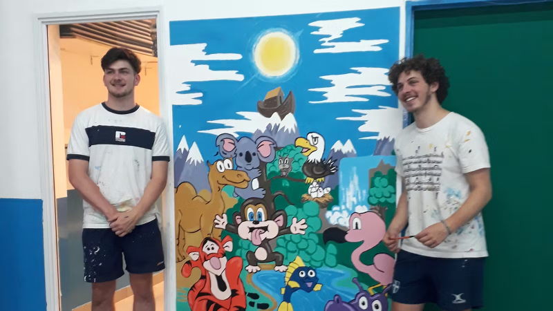 Two IVHQ Volunteers standing next to their finished mural