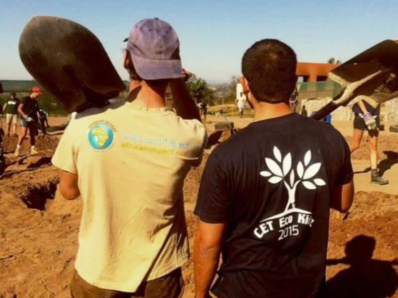 two male volunteers holding shovels
