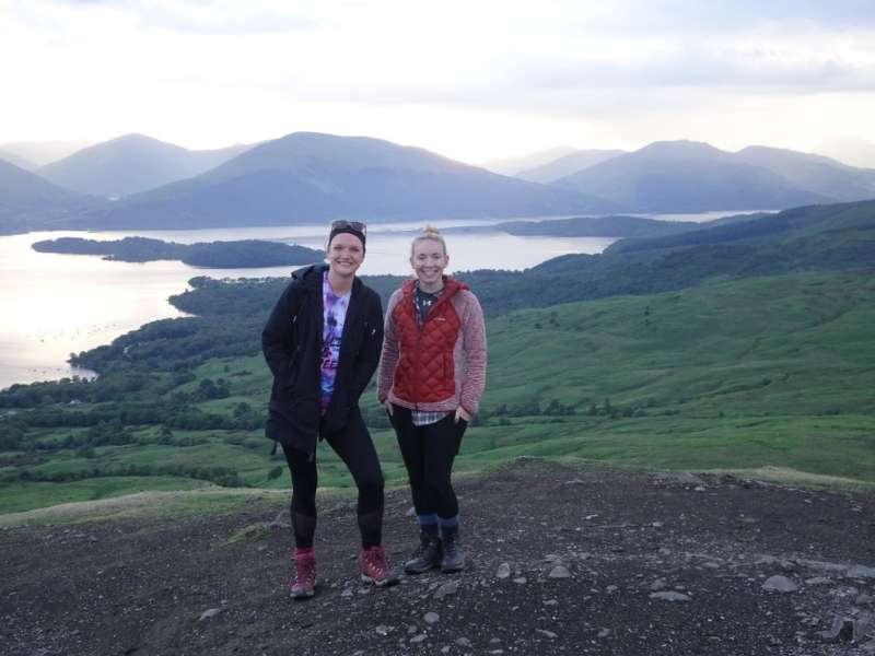 Two of our interns posing in front of a beautiful mountain view in Scotland!