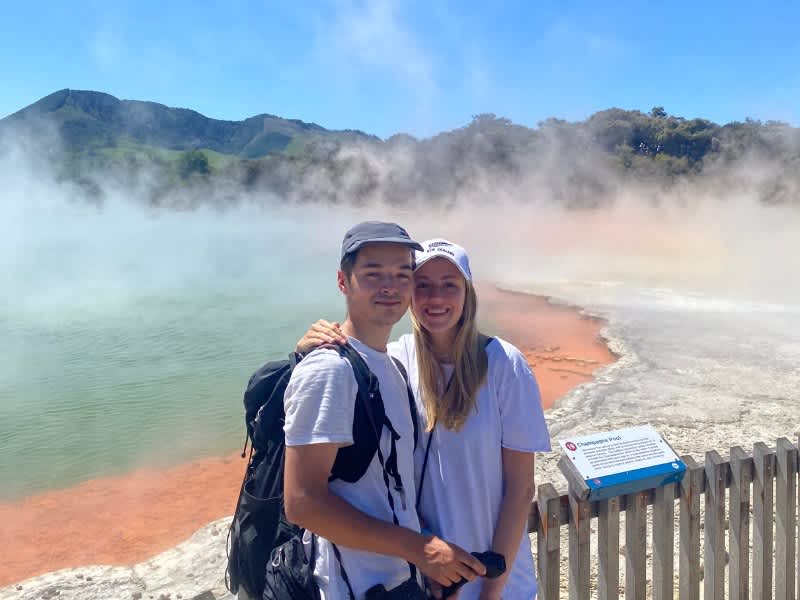 Two people in front of a geothermal pool