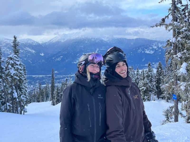 Two people on top of a snowy mountain in ski gear