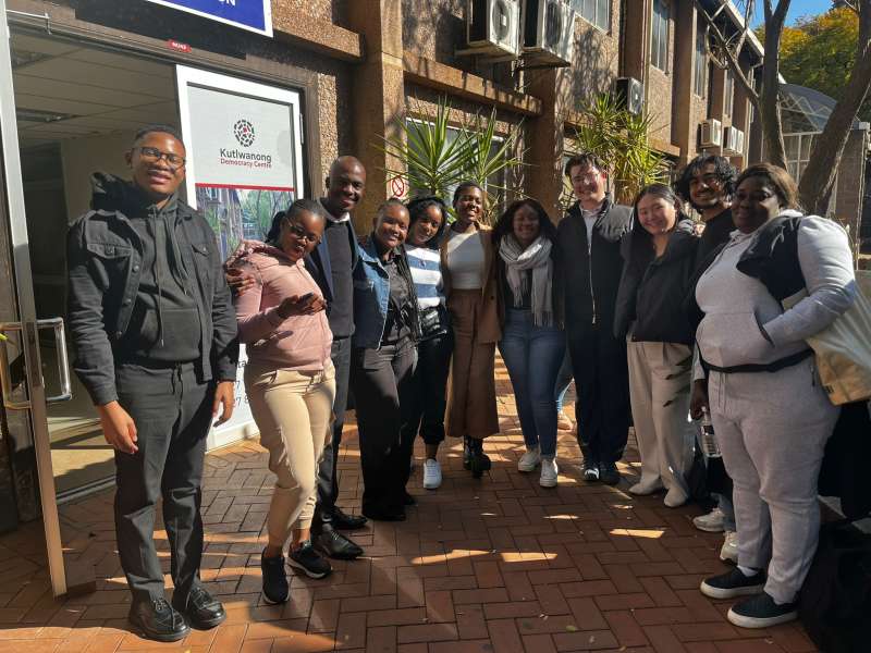 Two volunteers stand with the members of staff from the law clinic, outside of the building. 