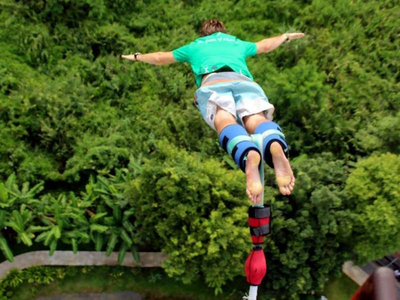 Volunteer bungee jumping in the middle of Thai jungle