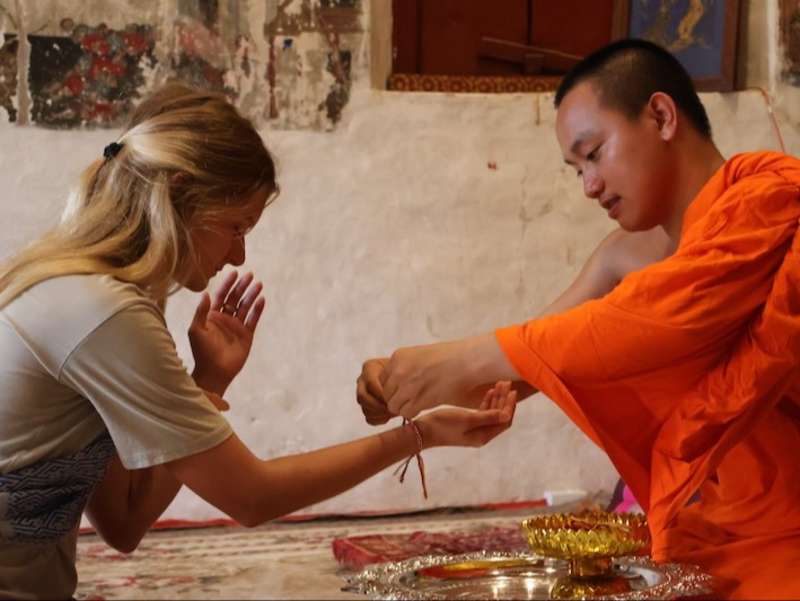Volunteer getting blessed by monk in Laos during local ceremony