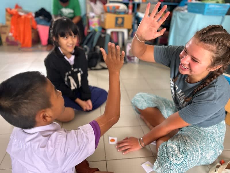 Volunteer teaching English to Thai children in local village