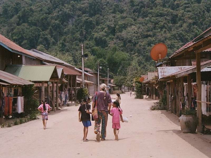 Volunteer walking through community with local children in Laos