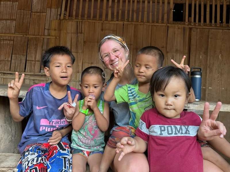 Volunteer with local Thai children in village in Thailand