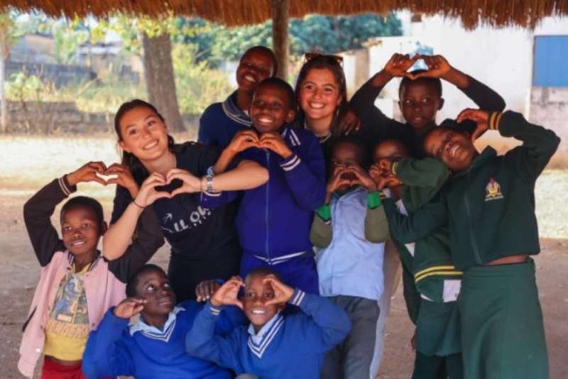 volunteers smiling with kids at homework club project