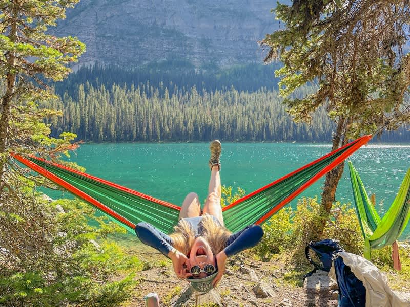 Woman in front of a lake in a hammock during summer
