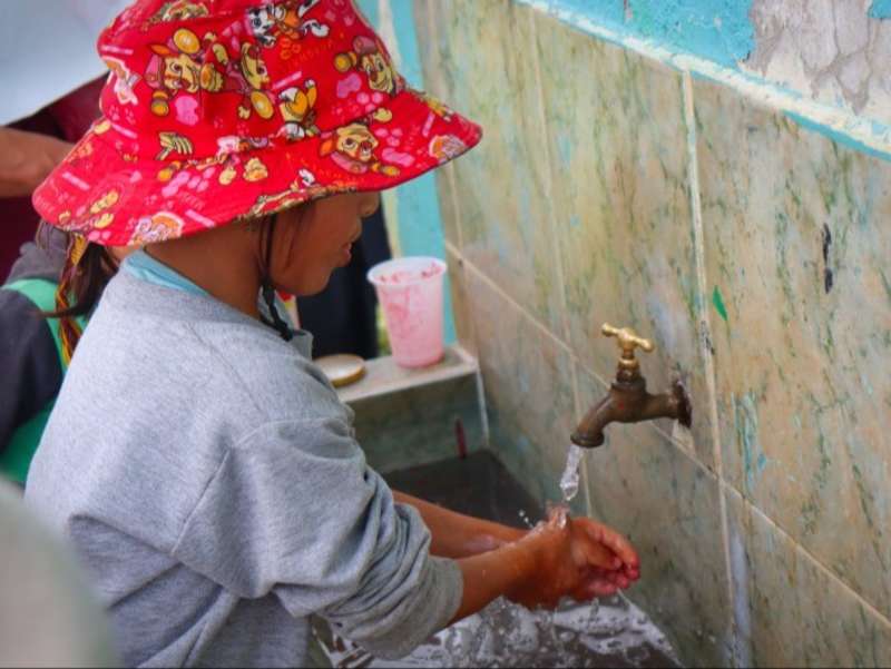 woman-washing-hands-water-tap-ecuador